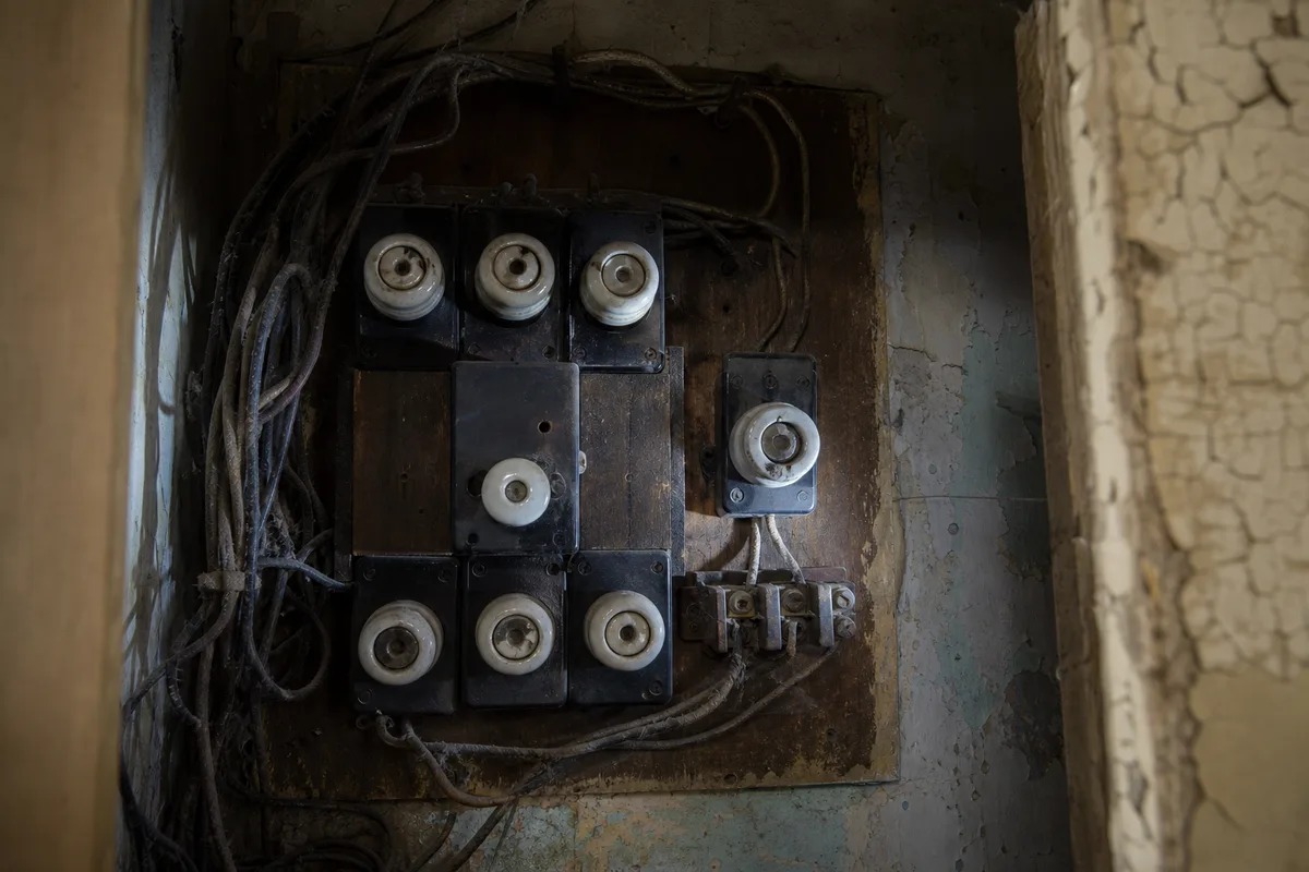 Tableau électrique ancien à fusibles au fond d&rsquo;un placard dans un logement lorientais